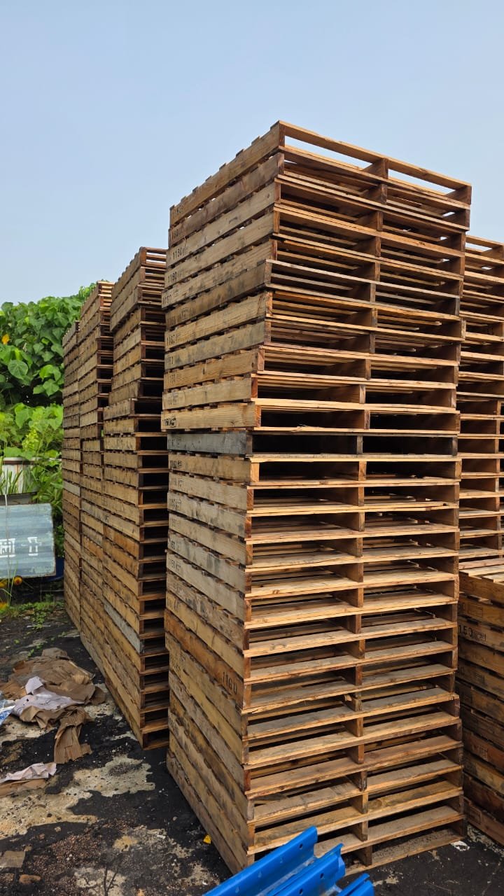 High-density stacked heavy-duty wooden pallets arranged neatly in an outdoor industrial storage yard, ideal for warehouse logistics, material handling, and freight transport solutions.